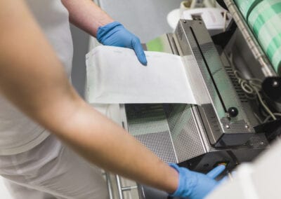 Donna adopera macchinario per sigillatura settore packaging